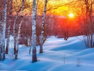 A bright orange sunset over a snowy scene
