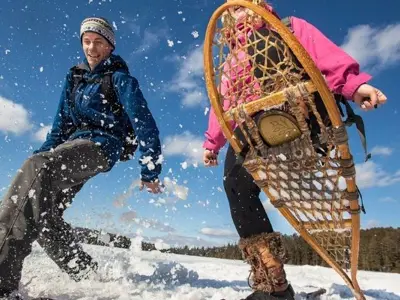 2 people snowshoeing and smiling