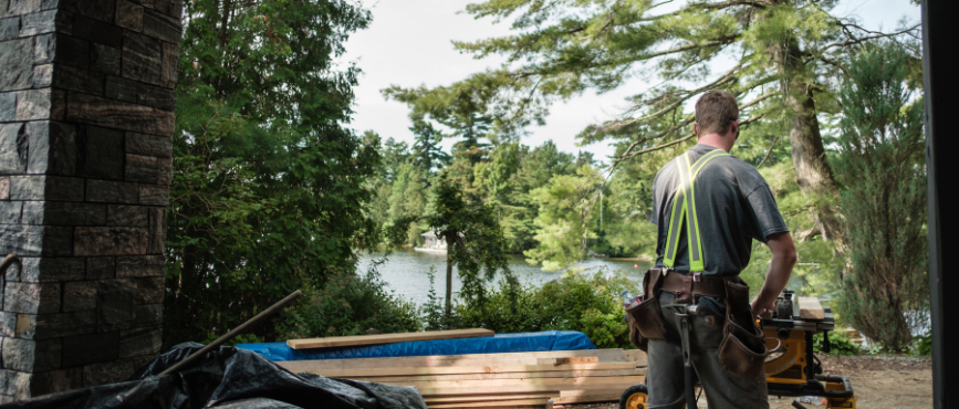 Building site with a builder cutting wood
