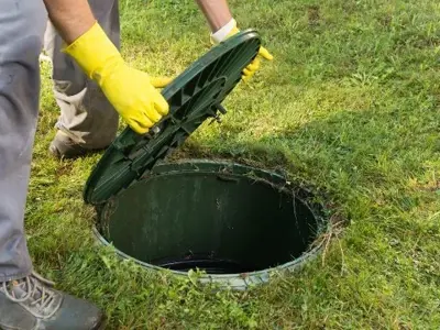 A septic tank lid being removed
