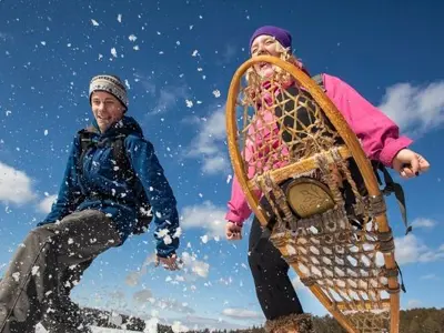 2 people snowshoeing and smiling